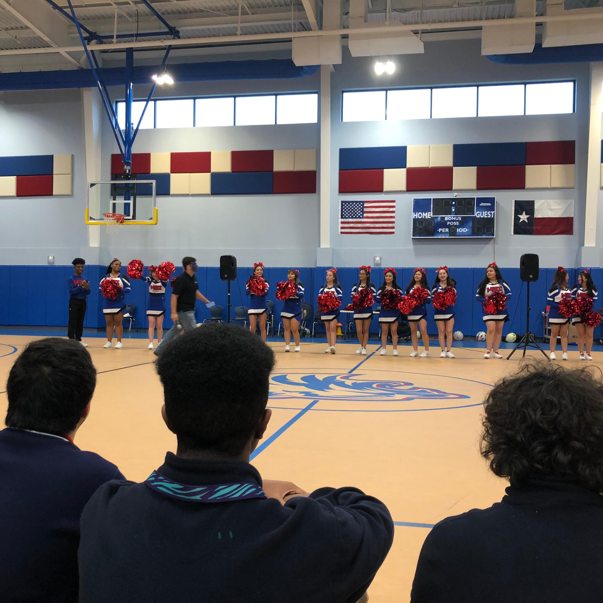 Student crowd watching cheerleaders before a game in the gym